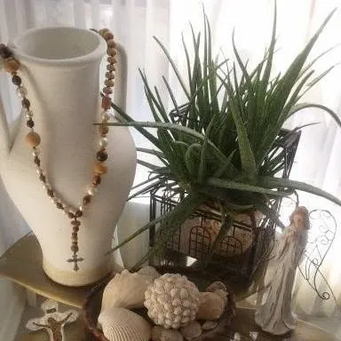 Collected necklaces, natural accents, and a small plant