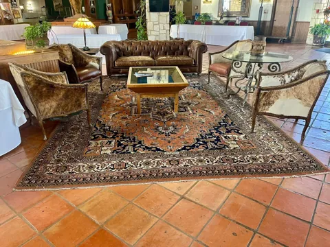 Historic hotel interior with a round table and hide chairs