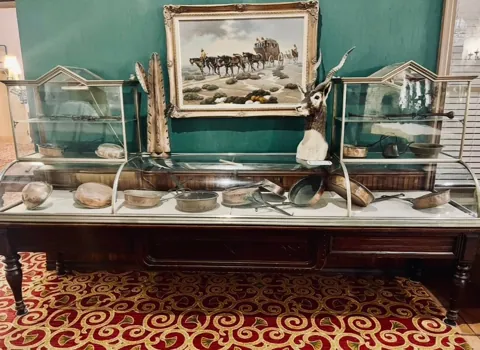 Antique cookware and treasured objects in a display cabinet
