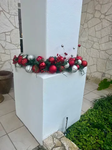 Red and green seasonal decorations in a white container