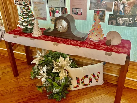 Holiday lettering and seasonal greenery on a mantel