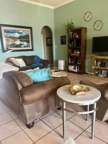 A leather sofa and small round table beside a bright window