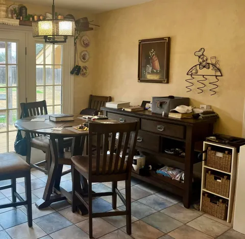 A wood dining table and chairs near a bright window