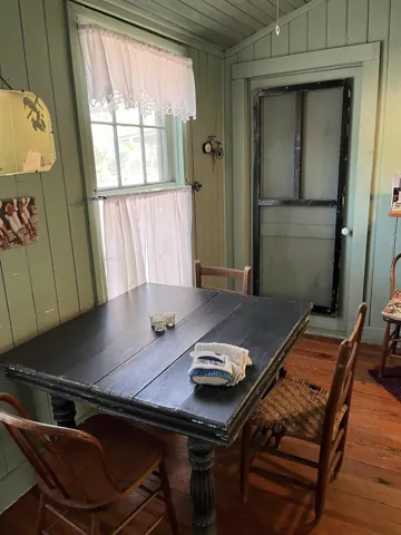 A dark wood dining table in a room with pale green paneling